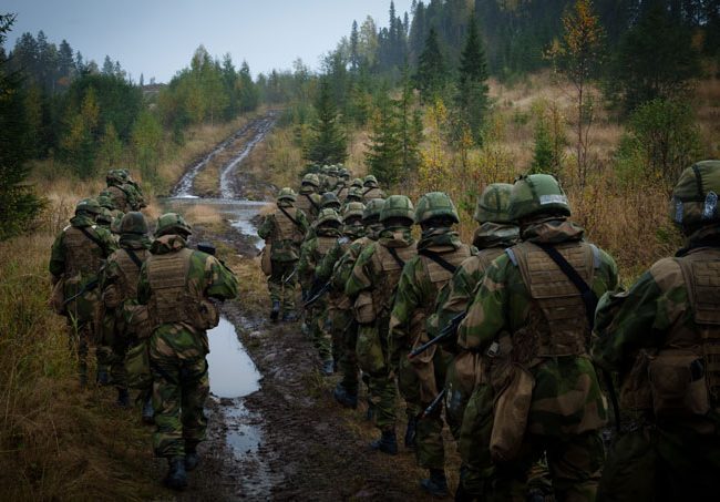 Soldater som går langs gjørmete vei