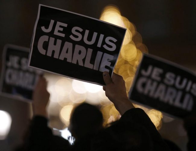 Hender som holder opp Je suis charlie-lapper