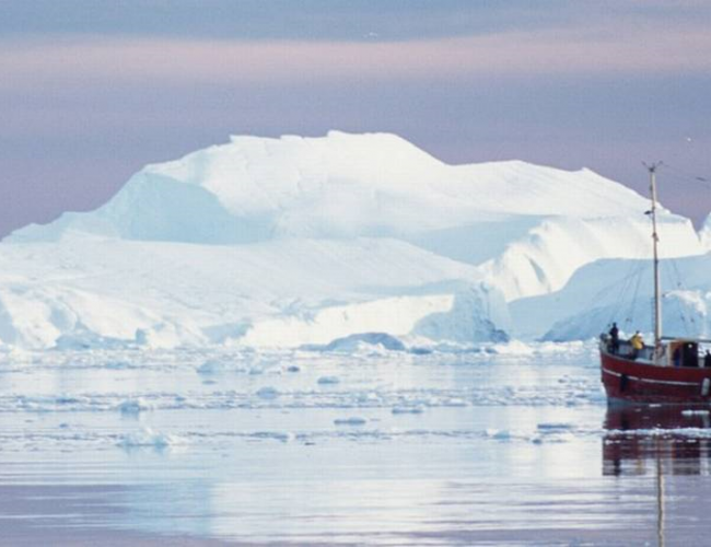 Hav med isfjell og fiskeskøyte