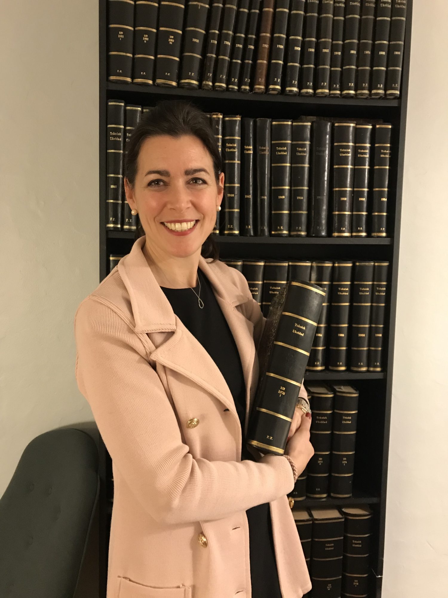 Ulrike Haugen, DNV GLs EVP og Chief Communications Officer, leser Teknisk Ukeblad for sitt fødselsår, foran bokhyllen hos Polyteknisk Forening.